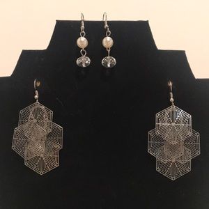 2 pairs of silver colored dangle earrings.